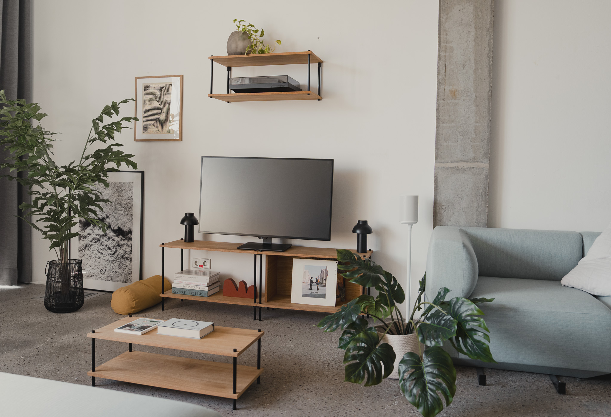 Wohnliches Wohnzimmer mit einem KUUDU Wandregal, einem KUUDU Media-Board und einem passenden KUUDU Couchtisch aus Eiche